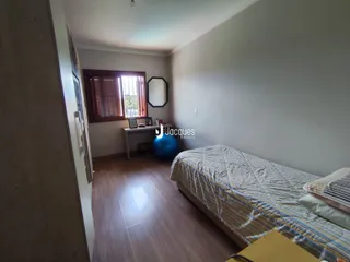 Quarto com piso de madeira e janela no interior de uma residência.