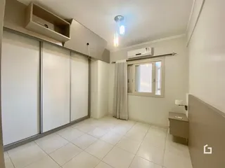 Foto de uma sala de estar clara com piso de cerâmica branca e armários embutidos.
