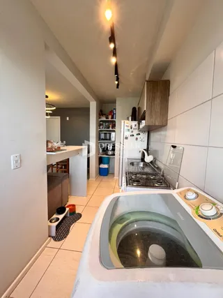 Foto de uma cozinha com revestimento cerâmico branco e eletrodomésticos.