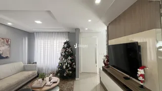 Sala de estar com sofá e árvore de Natal decorando o ambiente.