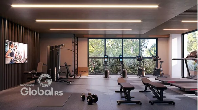 Interior de uma academia moderna com equipamentos de ginástica e grandes janelas.