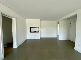 Ambiente interno de uma sala ampla com paredes brancas e piso de tom neutro.
