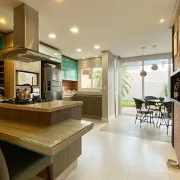 Sala de estar com bancada de cozinha moderna e piso claro.