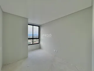 Interior de um ambiente com paredes brancas e piso de concreto.