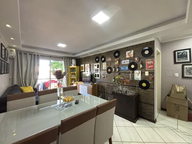 Sala de jantar com mesa de vidro e decoração na residência.
