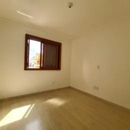 Uma sala de estar com uma janela de madeira visível na parede.