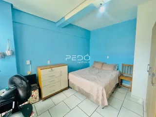 Quarto com cama e cômoda em ambiente de sala.