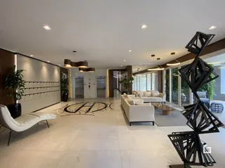 Sala de estar moderna com sofá branco e piso claro.