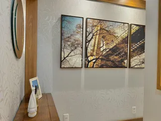 Uma parede interna decorada com papel de parede e quadros de arte.