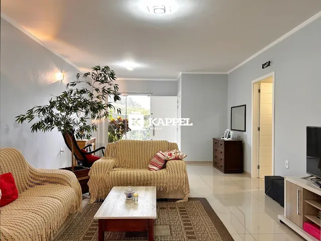 Sala de estar com sofá grande e decoração neutra.