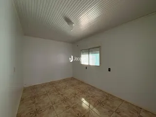Foto de um cômodo interno com piso de cerâmica marrom claro.