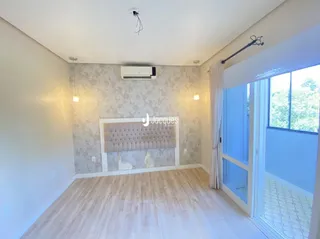 Sala de estar com piso de madeira clara e janela grande.
