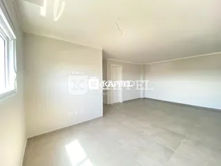 Ambiente interno com piso claro e paredes brancas em um imóvel.