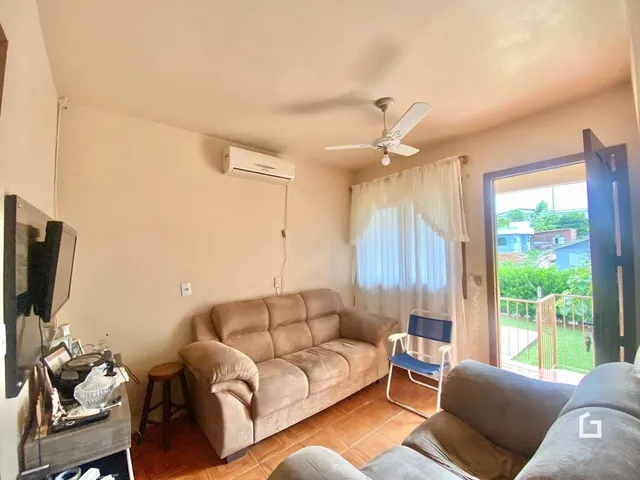 Sala de estar com sofá e vista para o quintal.
