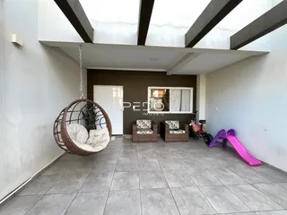 Área externa com piso de cerâmica e móveis de vime.
