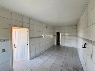 Corredor interno com piso de cerâmica e paredes brancas.