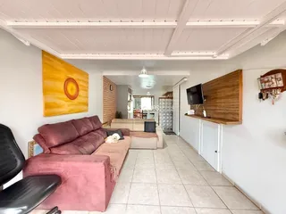 Sala de estar com sofá e decoração em ambiente claro.