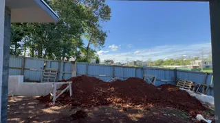 Vista externa de um terreno com cerca e terra acumulada.