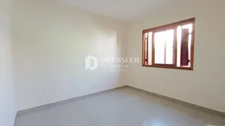 Ambiente interno de uma sala com piso de cerâmica e janela.