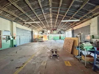 Espaço interno amplo com estrutura de teto exposta e paredes metálicas.