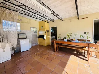 Imagem de uma sala com piso de cerâmica e estrutura de teto exposta.