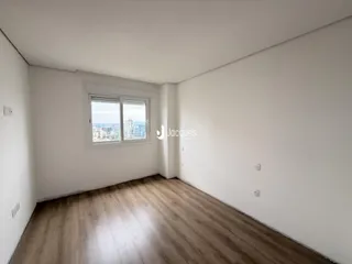 Ambiente interno com piso de madeira e vista da cidade.