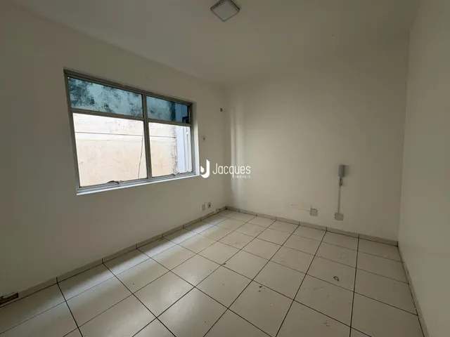 Ambiente interno de uma sala com piso de cerâmica e grande janela.