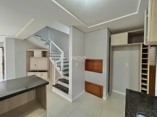Ambiente interno de uma sala com escadaria e armários em madeira.