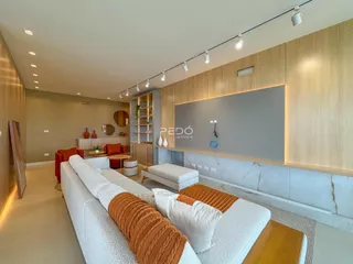 Sala de estar moderna com painéis de madeira clara e sofá.