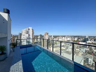 Vista panorâmica de uma piscina em um terraço com vista para a cidade.