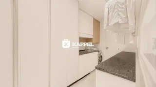 Cozinha com armários brancos e bancada de granito em ambiente claro.