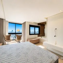 Quarto com cama grande e vista panorâmica da cidade.