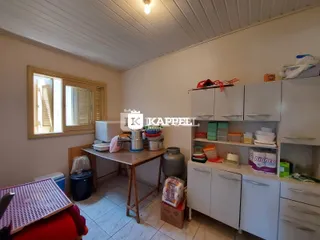 Foto interna de uma cozinha com armários brancos e piso de cerâmica.