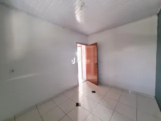 Hall de entrada com piso de cerâmica branca e paredes brancas.