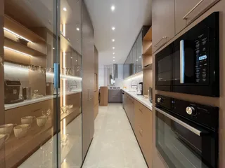 Cozinha moderna com armários de madeira e bancadas claras.