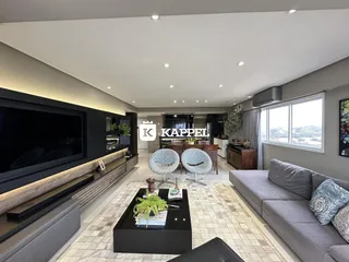 Sala de estar moderna com sofá e área de jantar em um imóvel em Lajeado.
