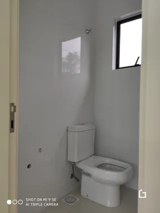 Foto de um banheiro interno com vaso sanitário e janela.