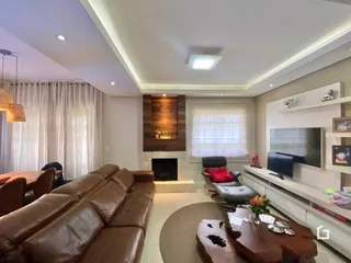Sala de estar com sofá de couro e lareira em um imóvel no Brasil.