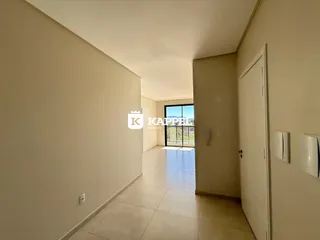 Um corredor interno com piso de cerâmica e vista para o exterior.