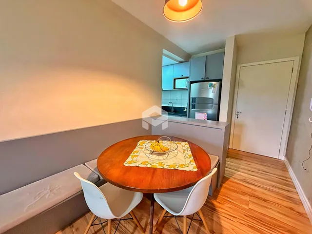 Ambiente interno com mesa de madeira e área de banho em um apartamento.