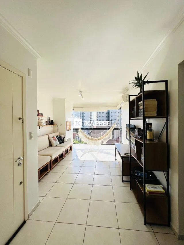 Sala de estar com sofá e piso de cerâmica claro.