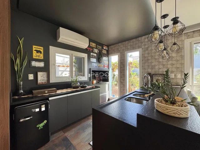 Uma cozinha moderna com armários cinzas e iluminação pendente.