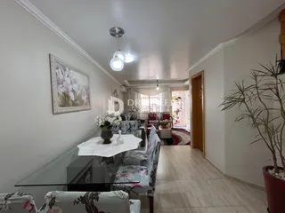 Sala de estar com decoração clara e móveis de vidro.