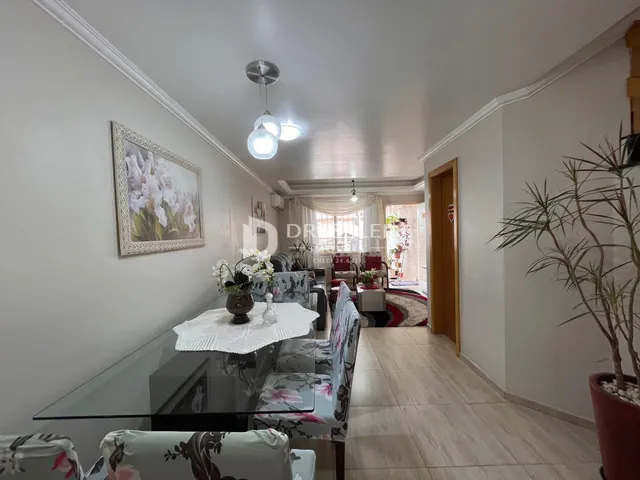 Sala de estar com decoração clara e móveis de vidro.