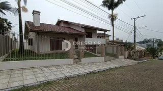 Fachada de uma residência em Lajeado, Brasil, com cerca e paisagismo.