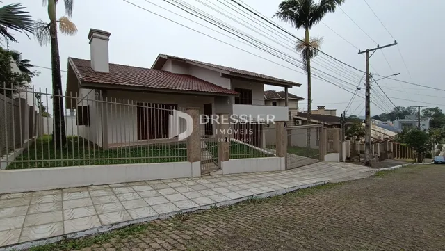 Fachada de uma residência em Lajeado, Brasil, com cerca e paisagismo.