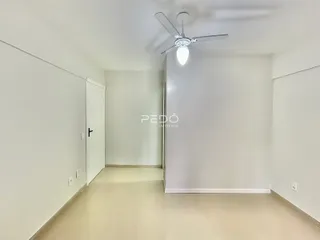 Corredor interno de uma residência com paredes brancas e piso claro.