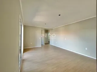 Hall de entrada com piso de madeira clara e paredes brancas.