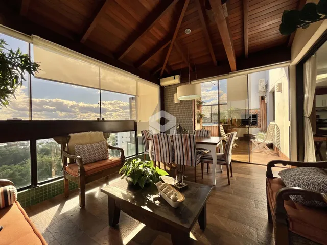 Sala de estar com pé direito alto e grandes janelas que oferecem uma vista panorâmica.