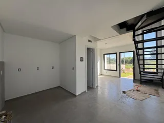 Ambiente interno amplo com piso de concreto e paredes brancas.
